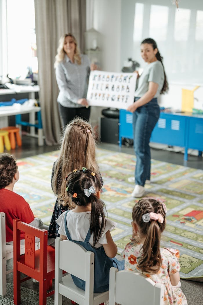 Young children engaged in a fun alphabet lesson with teachers in a kindergarten classroom.